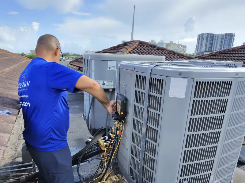 Technician servicing rooftop AC condensers in Miami