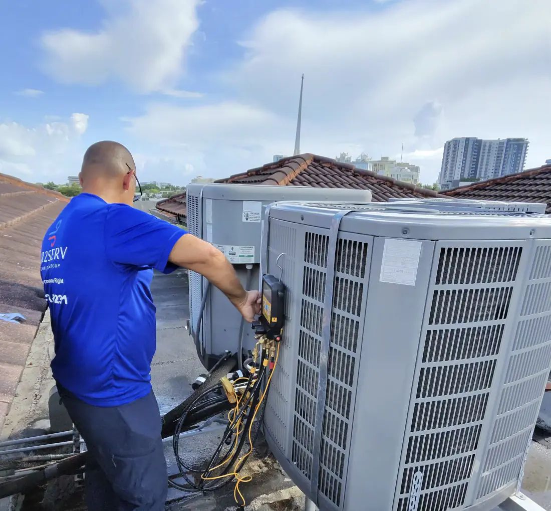 Technician servicing rooftop AC condensers in Miami