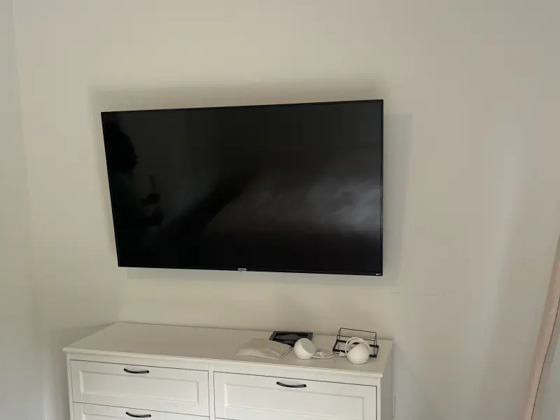 Wall-mounted television installed above a dresser